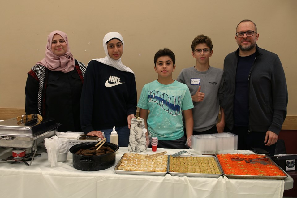 Deyala Al-katari, second from the left, runs a stall selling Palestinian food with her family at the fifth annual Ethnic Food Picnic at the Moose Hall on June 15.