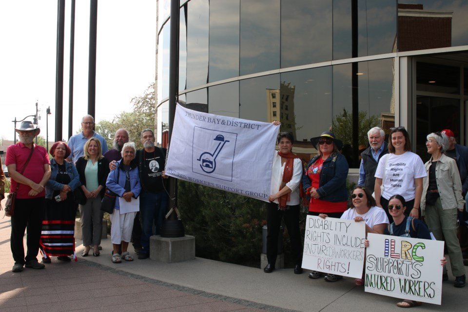 Over 20 representatives from the TBIWSG, the city, Lakehead University’s EPID@Work and other stakeholders in the community working alongside the group come together to raise the TBIWSG’s flag outside of the City Hall on May 30.