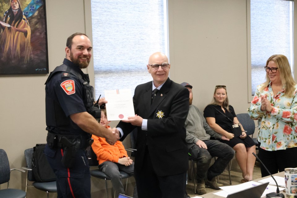 Thunder Bay police Const. Paul Kainulainen is presented with a St. John Ambulance life-saving award by the chair of the local organization, Lorne Clifford, and police board vice-chair Denise Baxter on May 20.