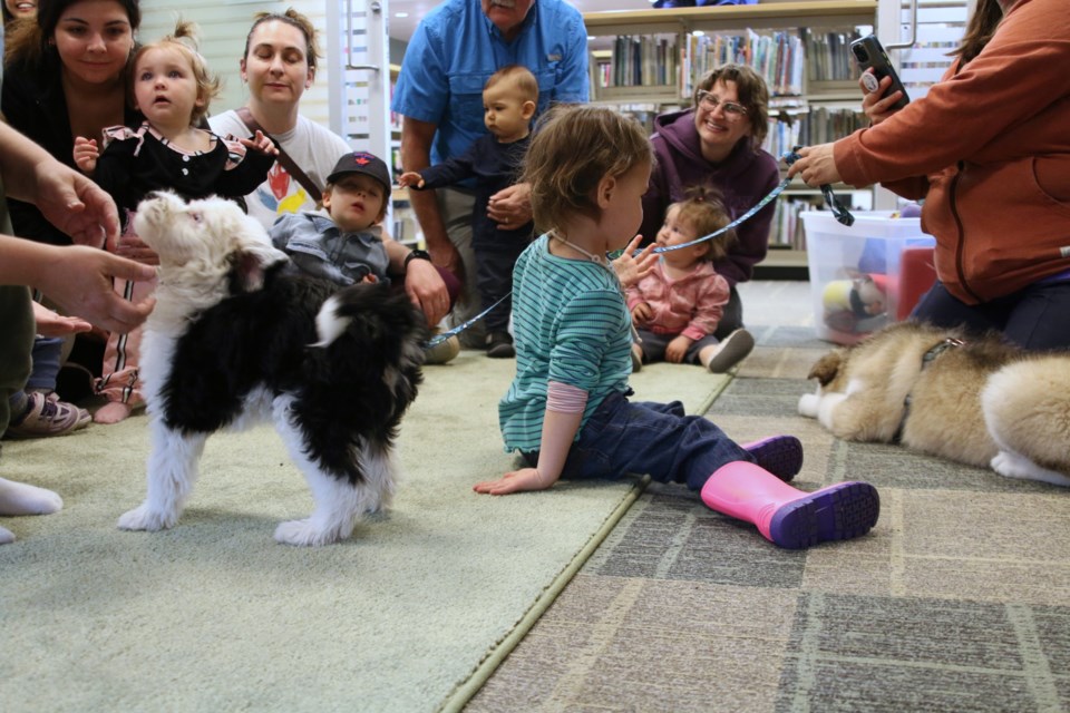 Several babies and toddlers participate in a puppy perks storytime at the Mary J.L. Black Public Library on Thursday morning.