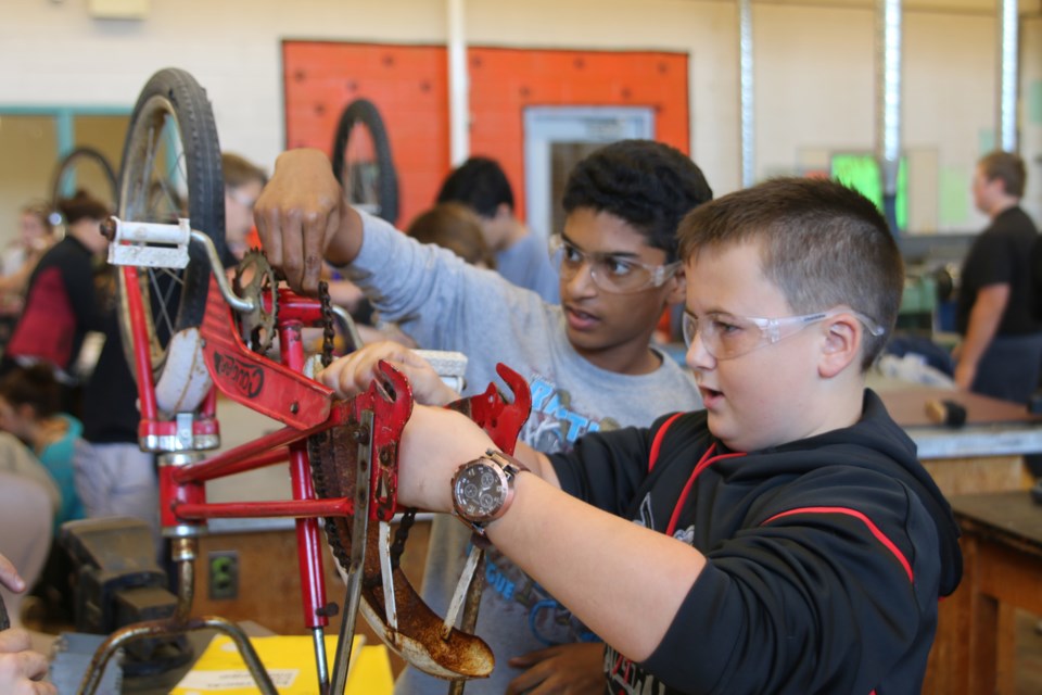 Grade seven and eight students from Westmount work on repairing bikes in the Westgate technical department, which will then be shipped to Africa as part of the Bicycles for Humanity program at Westgate High School. 