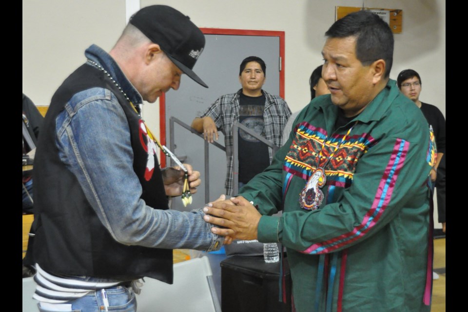Tragically Hip singer Gord Downie (left) is presented with an eagle feather on Sept. 8, 2016 by Marten Falls First Nation Chief Bruce Achneepineskum. 