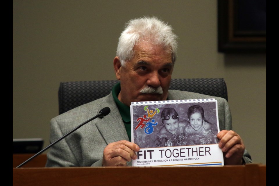 Coun. Joe Virdiramo holds up Fit Together, Thunder Bay's proposed Recreation Master Plan. 