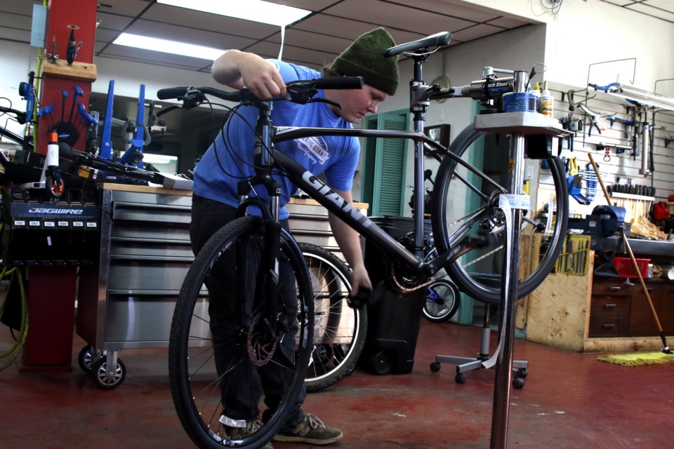 Bike mechanic Jordan Miller works on a bicycle in the Fresh Air shop.