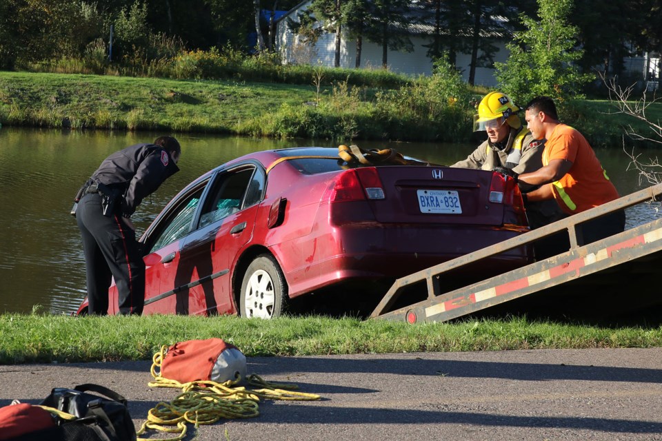 Police and fire crews assists a tow truck operator on Sept. 15, 2016 to remove a vehicle from the McIntyre River. No one was in the vehicle when emergency crews arrived to scene, adjacent to Carrick Street. (Photo by Leith Dunick, tbnewswatch.com)