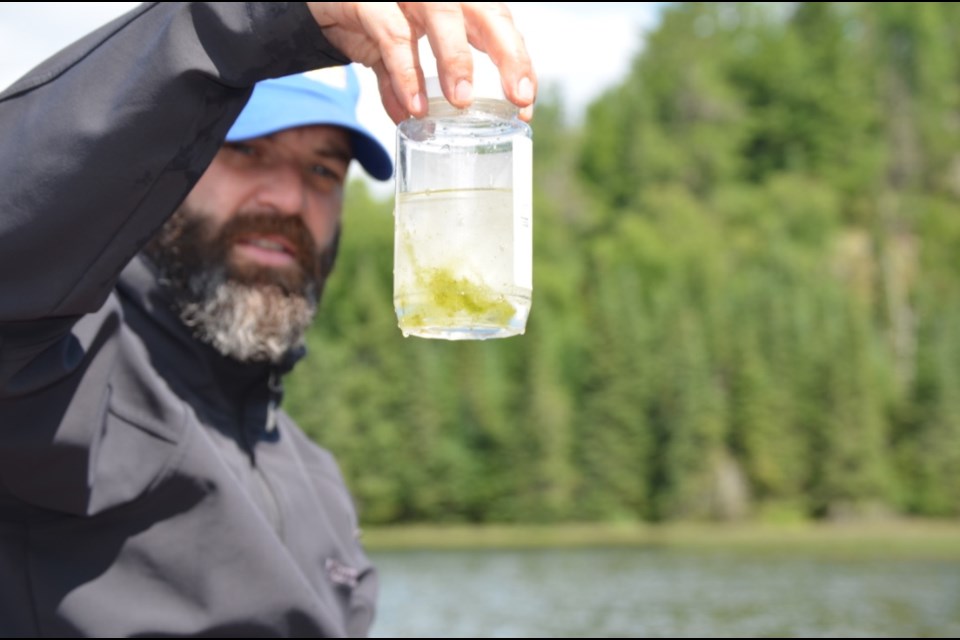 Dr. Rob Stewart holds a water sample showing algae. (photo supplied)