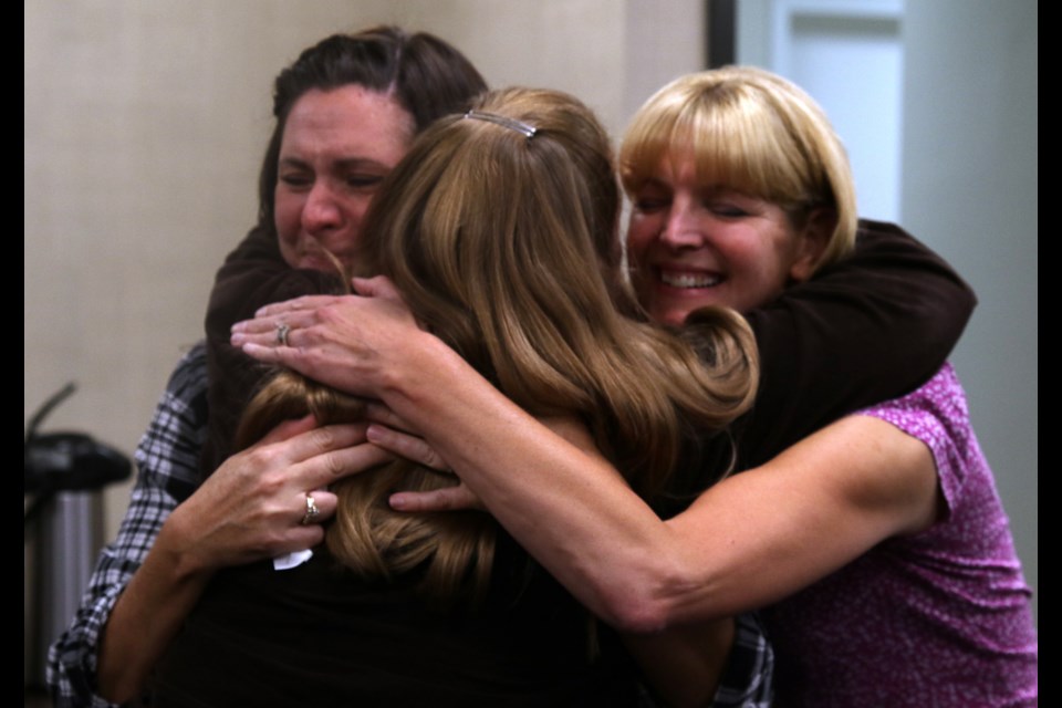 Lakehead District School Board meeting observers celebrate a Tuesday board decision to reject a plan for north side schools.