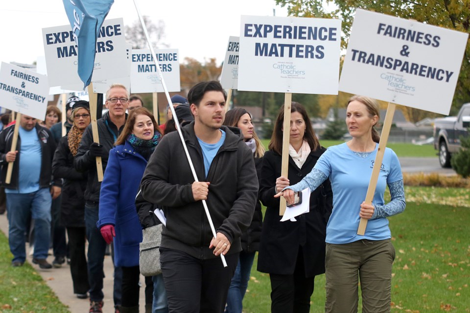 Members of the Thunder Bay branch of the Ontario Elementary Catholic Teachers Association march on Monday, Oct. 17, 2016 outside of the Thunder Bay Catholic District School Board office (Leith Dunick, tbnewswatch.com). 