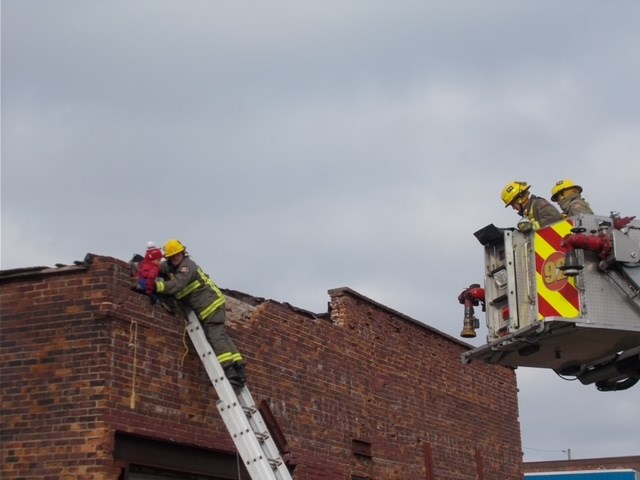 Firefighters used a ladder to reach the youth and keep him safe (TBFR photo)          