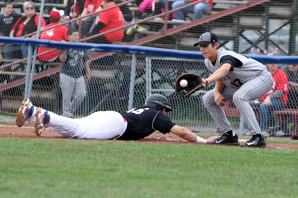 Border Cats baserunner Mark Venice slides back safely before La Crosse's Grant Judkins can apply the tag at first on Saturday, July 1, 2017 (Leith Dunick, tbnewswatch.com). 