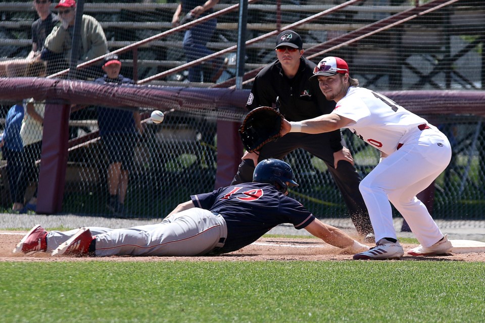 St. Cloud's Landon Stephens (left) dives back to safety as Thunder Bay's Brady Gulakowski awaits the pick-off attempt at first. (Leith Dunick, tbnewswatch.com)