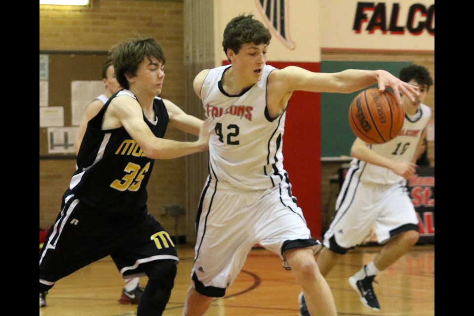 St. Ignatius Falcons forward Carter Harris reaches for the ball while being pursued by Fort Frances' Aaron Bujold on Saturday, Feb. 25, 2017. Harris had four points in the 81-33 Falcons win. (Leith Dunick, tbnewswatch.com)