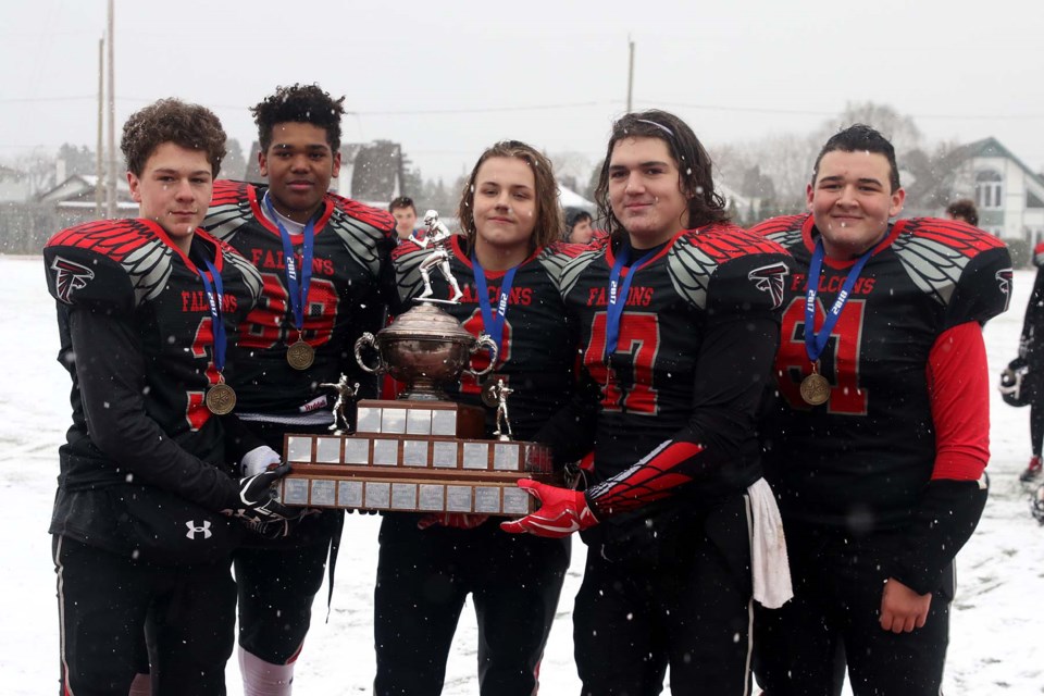 St. Ignatius Falcons captains Kevin White (from left), Isaiah Leonardi, Cameron Hughes, Brad Macklin and Thomas Caron accept the junior football championship trophy on Saturday, Nov. 4, 2017 at Fort William Stadium (Leith Dunick, tbnewswatch.com). 