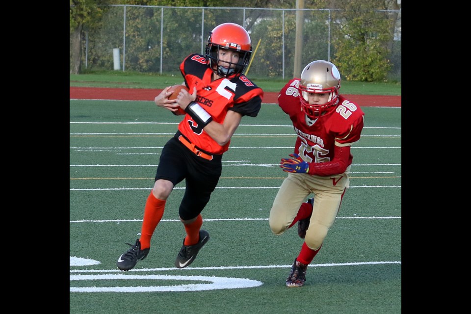 Westgate quarterback Jarek Jesperson tries to outrun Hammarskjold's Jordan Weiss on Thursday, Oct. 5, 2017 at Fort William Stadium (Leith Dunick, tbnewswatch.com). 