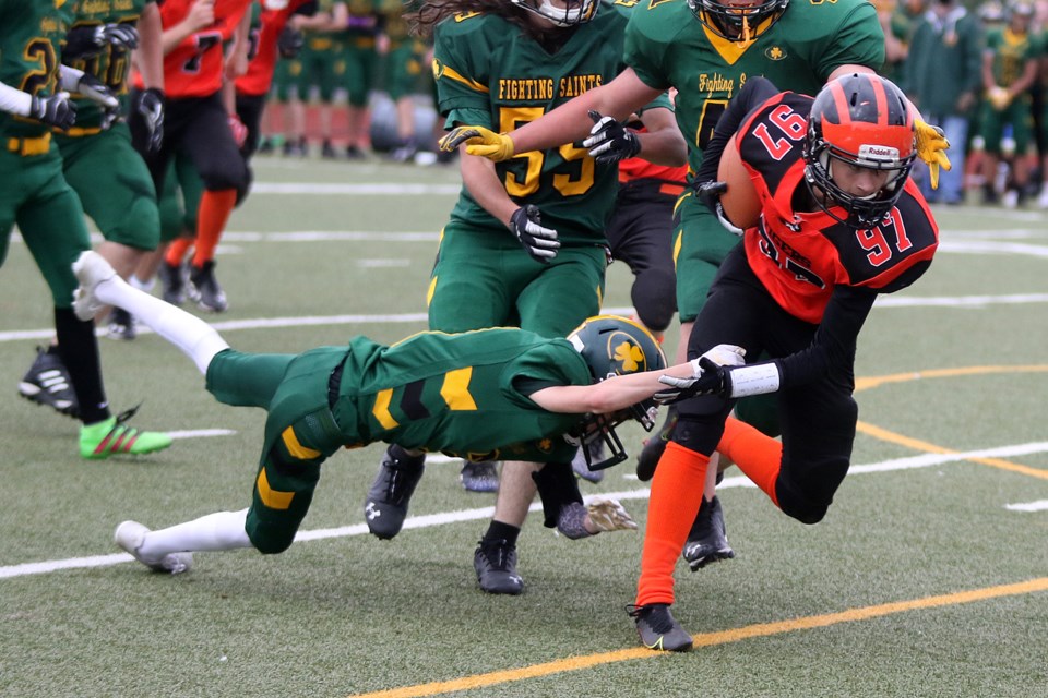 Westgate's Parker Mork (97) pushes for extra yardage with St. Patrick's Carson Auger trying to pull him down on Thursday, Oct. 14, 2021 at Fort William Stadium. (Leith Dunick, tbnewswatch.com)