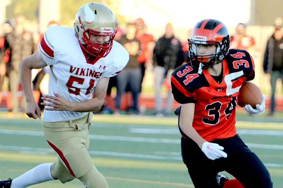 Westgate's Jack Popowich (right) is chased down by Hammarskjold's Aries King on Thursday, Sept. 22, 2022. (Leith Dunick, tbnewswatch.com)