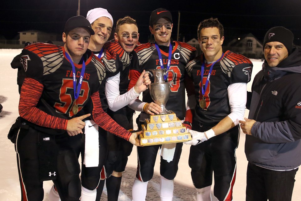 St. Ignatius captains Stefano Frattaroli (from left), Josh Newransky, Nic Cull, Bryce Covello and Liam Puskas hoist the trophy on Tuesday, Nov. 22, 2016 at Fort William Stadium following the senior boys high school football final (Leith Dunick, tbnewswatch.com). 