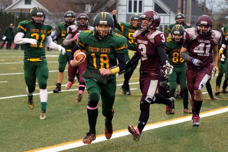 St. Patrick Saints quarterback Eric Nisiou (18) scrambles two yards into the endzone, Churchill's Connor Byerley (3) and Zach Bakker (41) too late to stop him from crossing the goal line on Friday, Oct. 28, 2016 (Leith Dunick, tbnewswatch.com). 