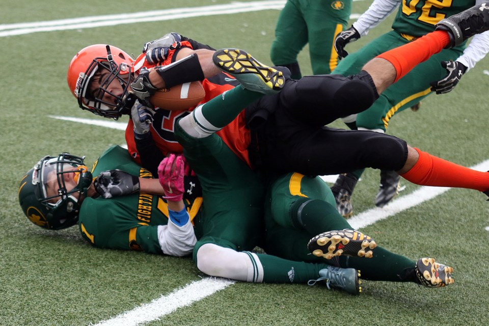 Westgate's Keegan Stoger (top) is hauled down by St. Patrick defender Brendan Chomut on Friday, Oct. 21, 2016 at Fort William Stadium (Leith Dunick, tbnewswatch.com). 