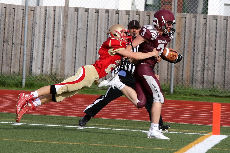 Churchill's Connor Byerley (right) drags Hammarskjold defender Travis Halls across the goal line on Friday, Sept. 22, 2017 at Fort William Stadium (Leith Dunick, tbnewswatch.com). 