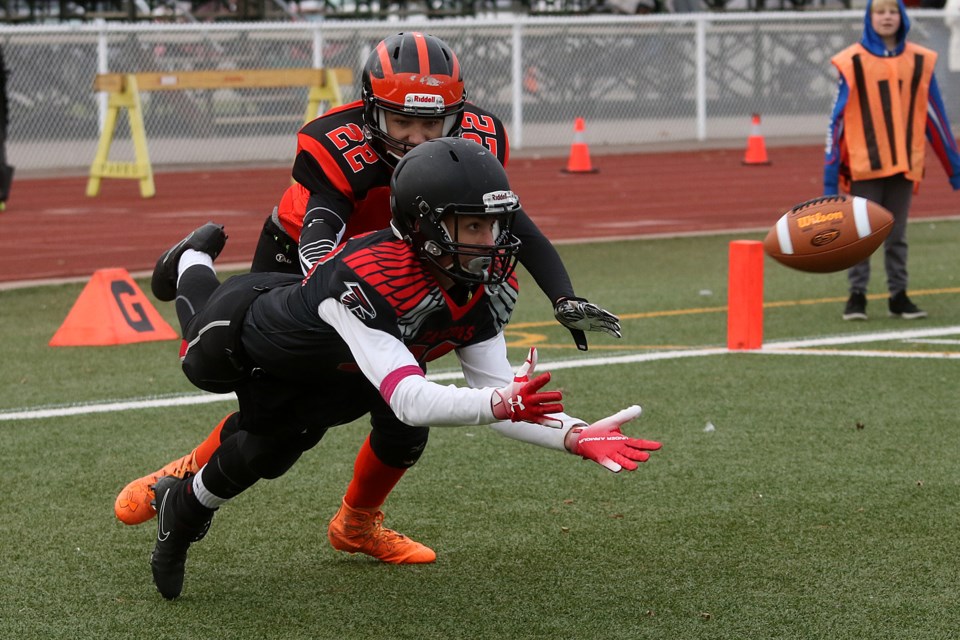 St. Igatius Falcons receiver Trent Savard dives for a possible touchdown catch with Westgate's Zach Woods draped all over him on Friday, Oct. 12, 2018 at Fort William Stadium. (Leith Dunick, tbnewswatch.com)