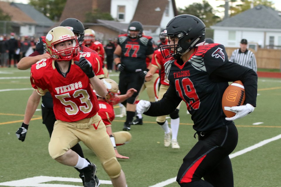 Hammarskjold's Jack MacLeay (left) chases down St. Ignatius Falcons back Liam Willmore on Friday, Sept. 24, 2021 at Fort William Stadium. (Leith Dunick, tbnewswatch.com)