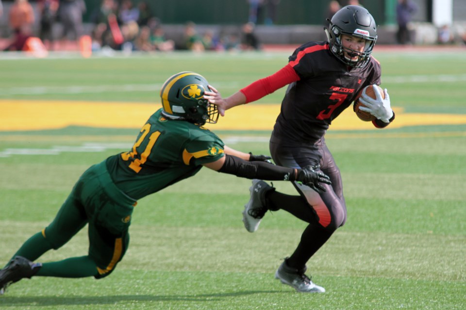 Falcons quarterback Lucas Dupuis fights off a tackle attempt by St. Patrick's Preston Shapwaykeesic-Dupuis during their high school senior football game on Friday, September 15, 2023. (Matt Vis, TBnewswatch.com)