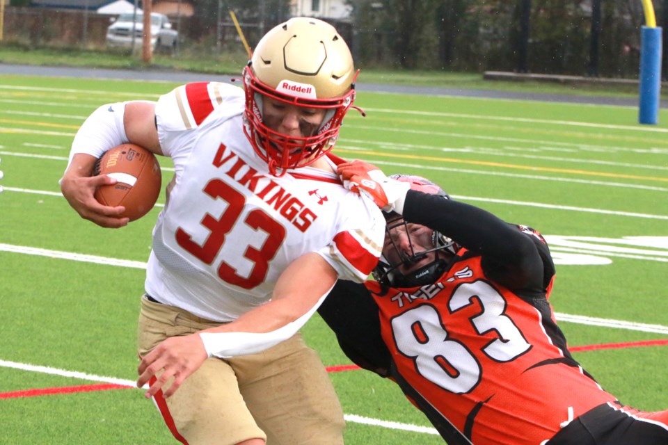 Westgate's Evan Wilson (right) tries to pull down Hammarskjold's Gerald Marshall on Friday, Oct. 6, 2023 at Fort William Stadium. (Leith Dunick, tbnewswatch.com)