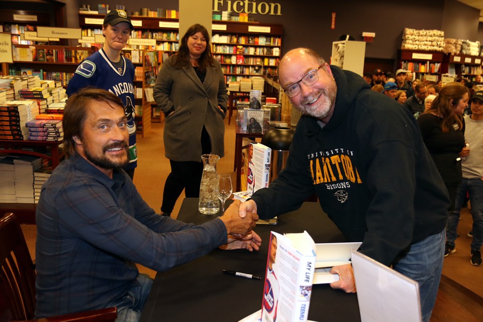 Kevin Cleghorm (right) shakes hands with NHL legend Teemu Selanne on Wednesday, Oct. 30, 2019 at Chapters' Thunder Bay store. (Leith Dunick, tbnewswatch.com)
