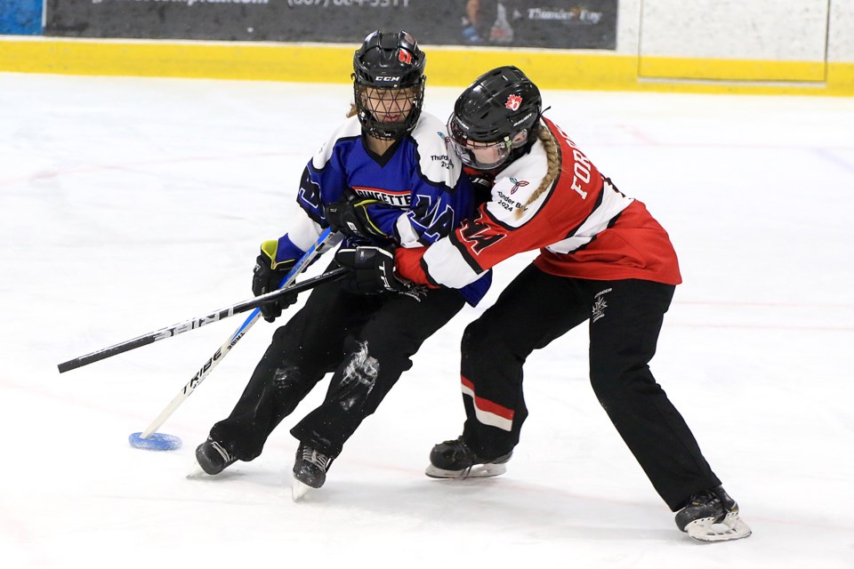 Team Blue's Teagan Setterfield (left) battles Team Red's Morgan Forrest on Friday, Feb. 16, 2024 on Day 1 of the Ontario Winter Games at Thunder Bay's Delaney Arena. (Leith Dunick, tbnewswatch.com)