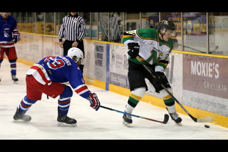 Thunder Bay's Brad Thrower (right) works along the boards, trying to skate past Minnesota Iron Rangers captain Isaiah Olschewske on Saturday, Dec. 3, 2016 at Fort William Gardens (Leith Dunick, tbnewswatch.com).