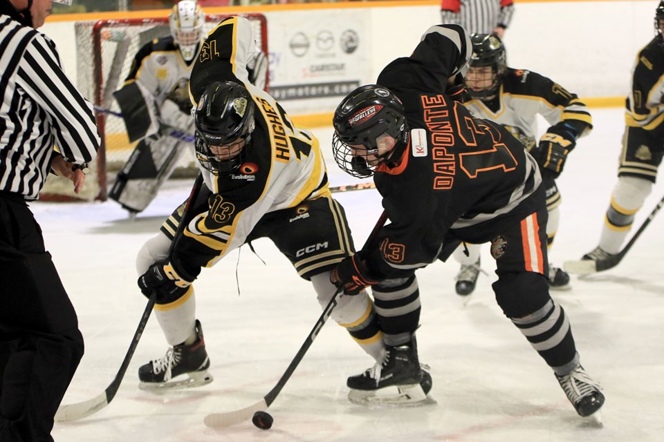 Kam River's Ryan Daponte (right) battles Red Lake's Kai Hughes in the faceoff circle on Saturday, March 16, 2024 at the Norwest Arena. (Leith Dunick, tbnewswatch.com)