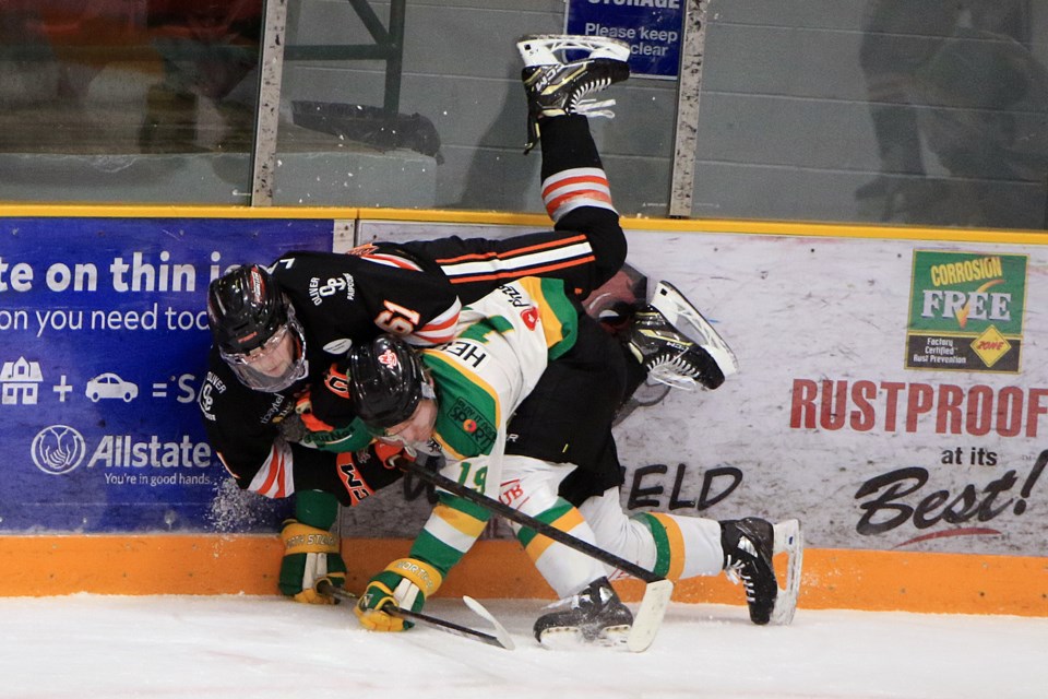 Kam River's Caleb Labelle (left) and Thunder Bay's Beau Helmeczi tangle against the boards on Friday, Dec. 6, 2024 at Fort William Gardens. (Leith Dunick, tbnewswatch.com)