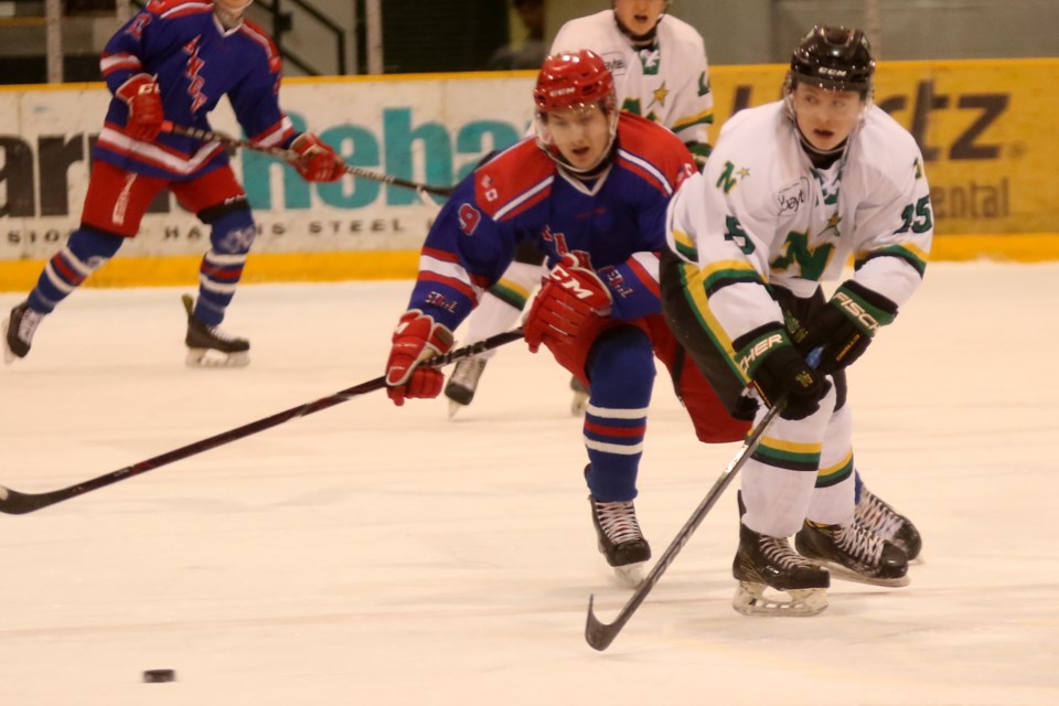 Thunder Bay's Kyle Auguer (right) and Minnesota's Aaron Koivunen chase down the puck on Monday, March 19, 2018 in SIJHL playoff action at Fort WIlliam Gardens. (Leith Dunick, tbnewswatch.com)