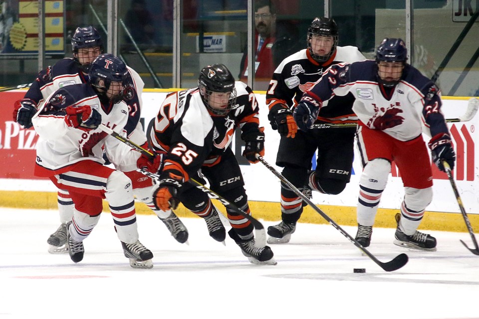 Magog's Justin Robidas (25) tries to break free against a trio of Tisdale Trojans in semifinal play at the TELUS Cup on Saturday, April 27, 2019 at Fort William Gardens. (Leith Dunick, tbnewswatch.com)