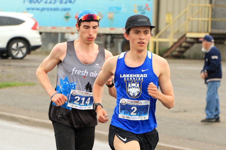 Winner Jett Dobson (right) runs with fourth-place finisher Finn Dodgson during the Firefighters Ten Mile Road Race on Monday, May 20, 2024. (Leith Dunick, tbnewswatch.com)