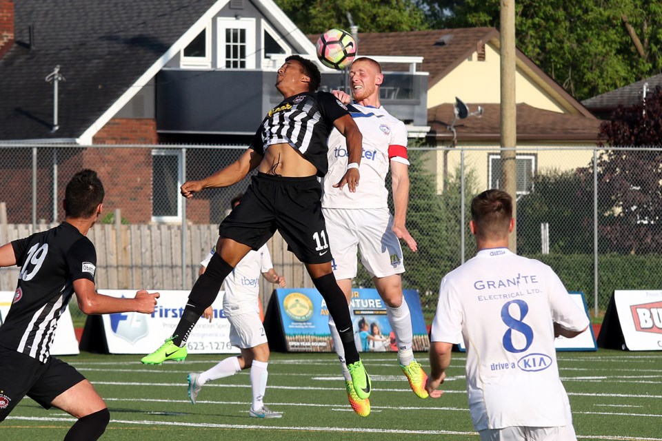 Des Moines' Christopher Nkogie and Thunder Bay's Mitchell Osmond jump for the ball on Saturday, June 10, 2017 at Fort William Stadium (Leith Dunick, tbnewswatch.com). 