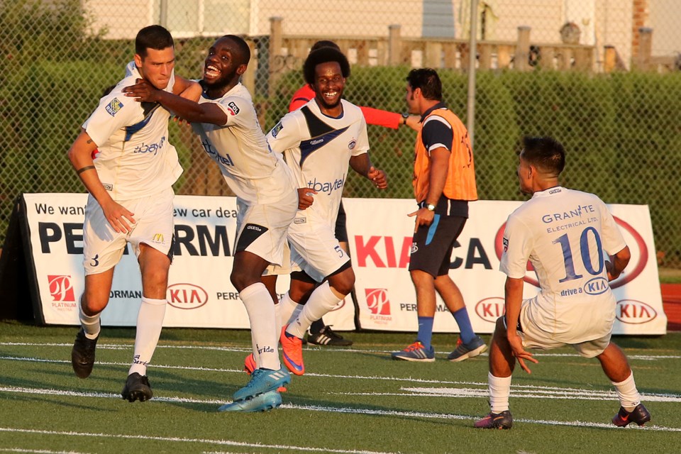Luca Mastrantonio (left) is mobbed by teammates Chris Makengo, Zetroy Robertson and Abraham Villon after scoring in the 58th minute on Saturday, July 29, 2017 to send the Thunder Bay Chill to their fourth Premier Development League final since 2008 (Leith Dunick, tbnewswatch.com). 