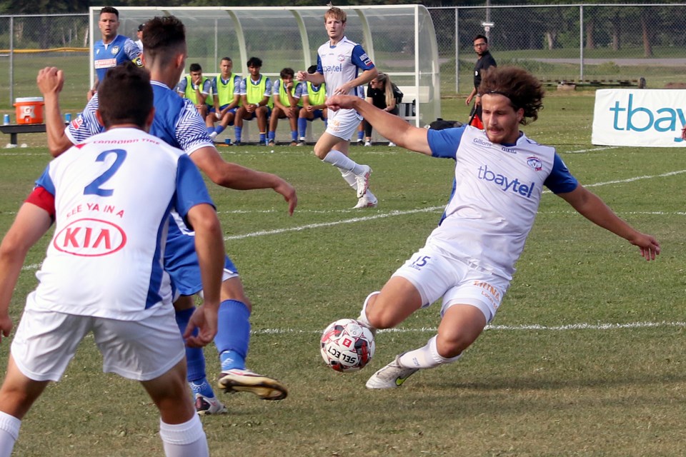 Thunder Bay's Jag Arena slides into the ball on Saturday, July 16, 2022 against an FC Manitoba defender. (Leith Dunick, tbnewswatch.com)