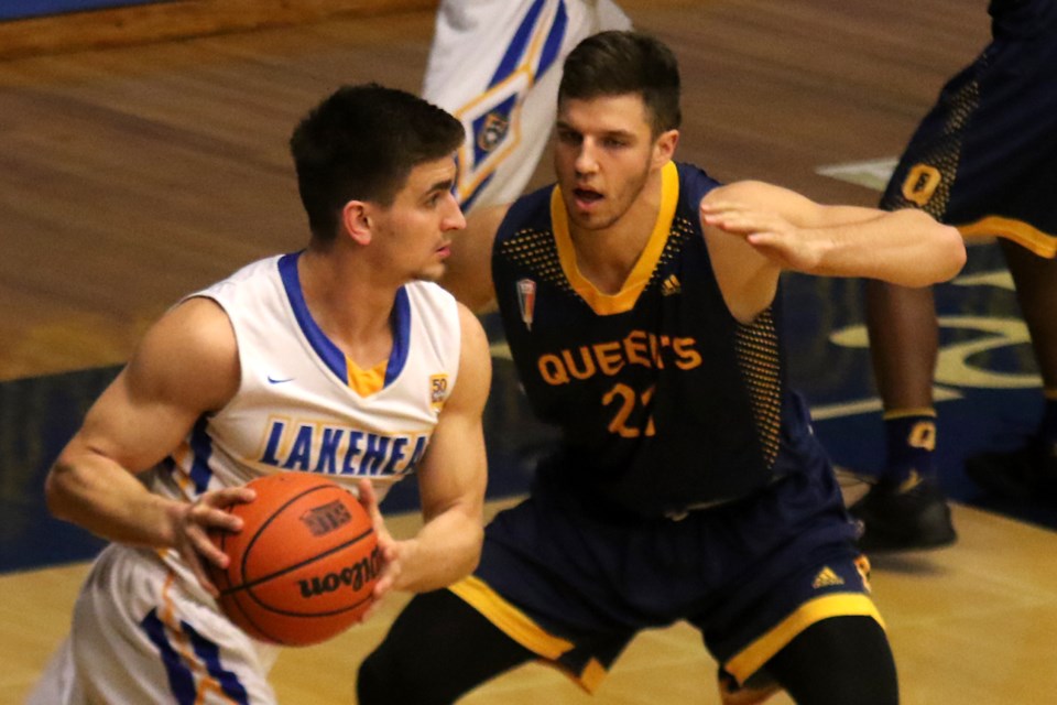 Thunderwolves guard Alex Robichaud (left) works his way past Queen's Isaiah Wilson on Friday, Nov. 25, 2016 at the Thunderdome (Leith Dunick, tbnewswatch.com). 