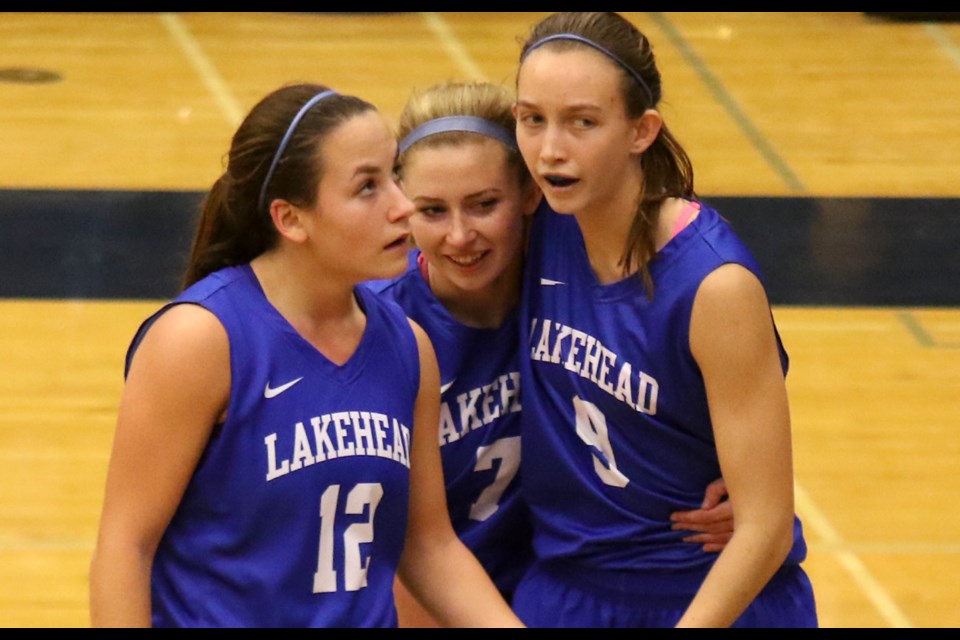 Maggie Murphy (centre) is congratulated by teammates Jerika Baldin and Lindsay Edward (right) on Saturday, Nov. 26, 2016 after playing her final game with the Lakehead Thunderwolves (Leith Dunick, tbnewswatch.com). 