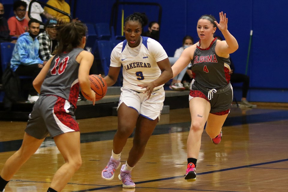 Lakehead's Tiffany Reynolds (centre) looks for space between Algoma's Thais Matte (10) and Allison Read (4), who is a graduate of the Westgate Tigers program. (Leith Dunick, tbnewswatch.com)