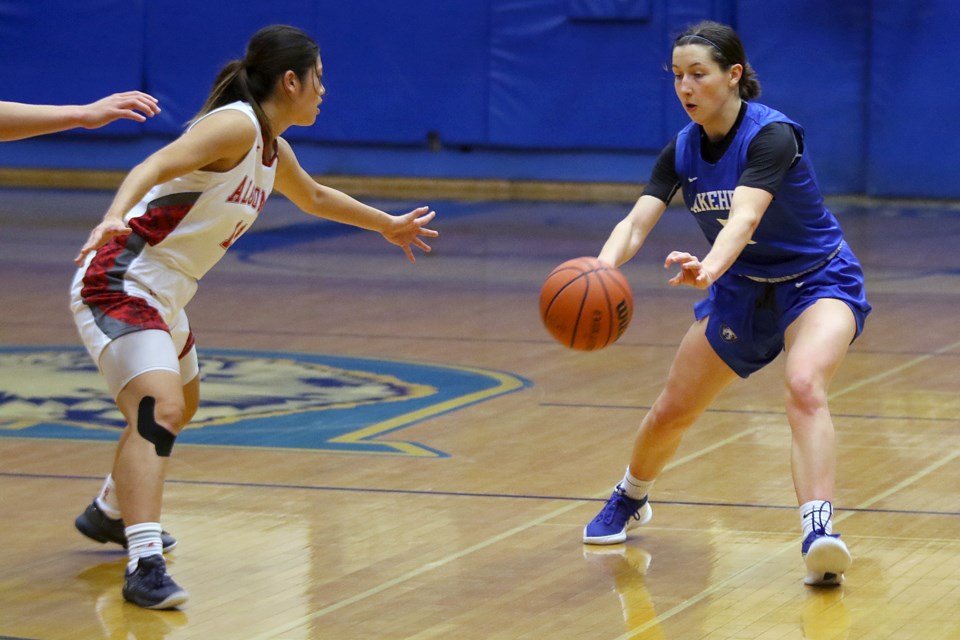 Lakehead's Ally Burke (left) makes a pass as Algoma's Ayaka Nakashima looks to guard the lane on Sunday, Oct. 24, 2021. (Leith Dunick, tbnewswatch.com)