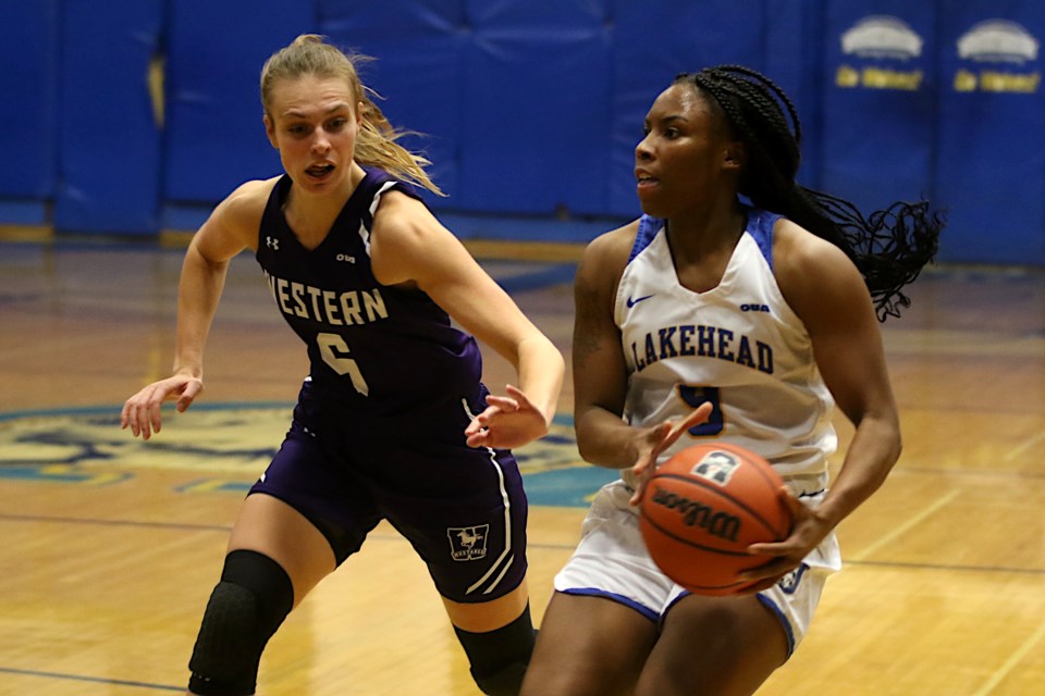 Tiffany Reynolds, battling Western's Ashley Wheeler, finished with 18 points against the Mustangs on Friday, Nov. 26, 2021. (Leith Dunick tbnewswatch.com)