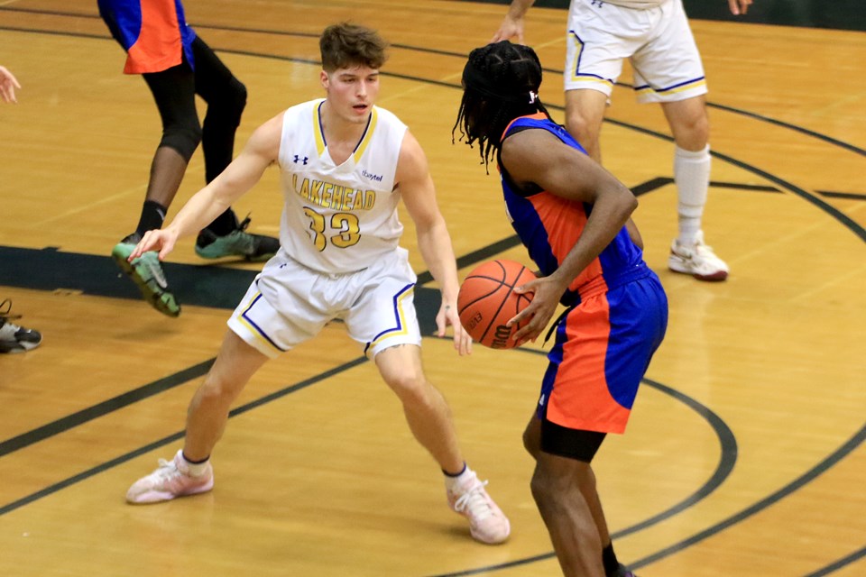 Lakehead's Jared Kreiner (left) guards Ontario Tech's Levi Ogbonna on Saturday, Feb. 10, 2024. Kreiner was playing in his final home game with the Thunderwolves. (Leith Dunick, tbnewswatch.com)