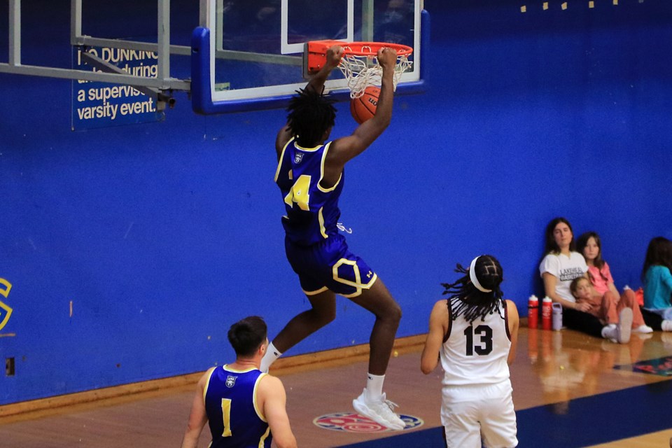 Keylian Coulibaly hangs on the rim after a dunk on Saturday, Nov. 2, 2024. (Leith Dunick, tbnewswatch.com)