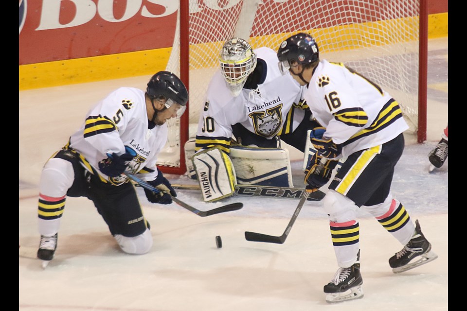 Thunderwolves defenceman Tyler Anton and forward Dylan Butler work to clear the puck from the front of goalie Devin Green's net on Saturday, Oct. 1, 2016 at Fort William Gardens