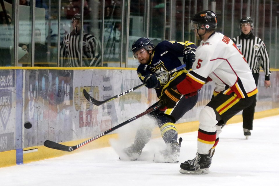 Lakehead's Patrick Murphy (left) fires the puck around the boards past Guelph's Jesse Saban on Saturday, Feb. 2, 2019 at Fort William Gardens. (Leith Dunick, tbnewswatch.com)
