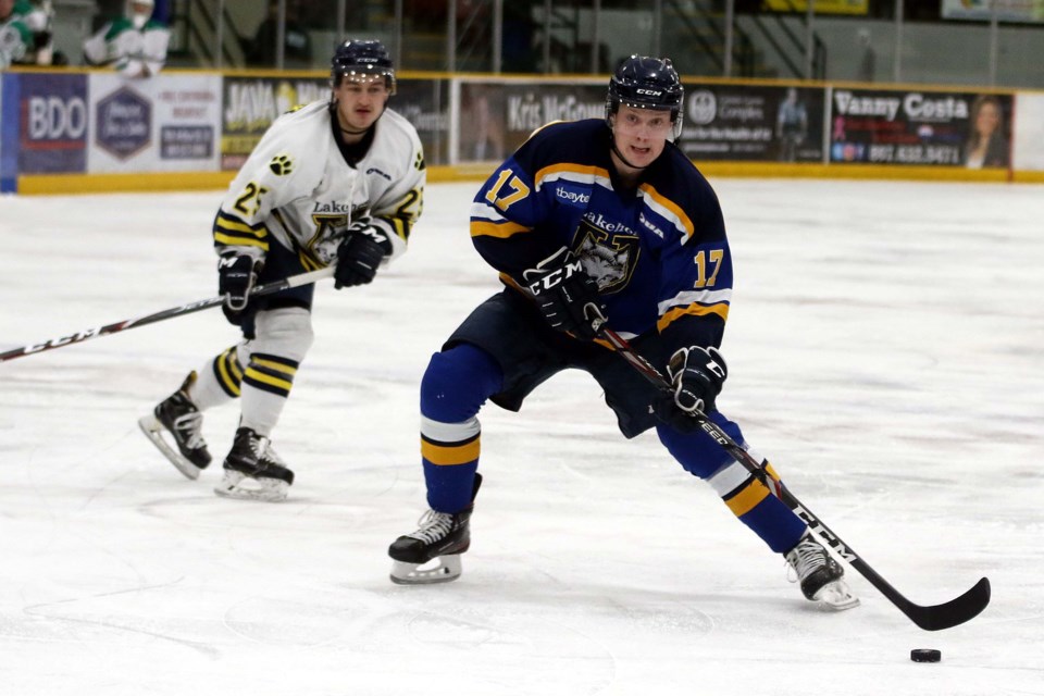 Lakehead's Taylor Egan (right) moves in for a shot as his Thunderwolves teammate Daniel McKitrick, playing for the Thunder Bay North Stars, looks on, on Sunday, Dec. 29, 2019. (Leith Dunick, tbnewswatch.com)