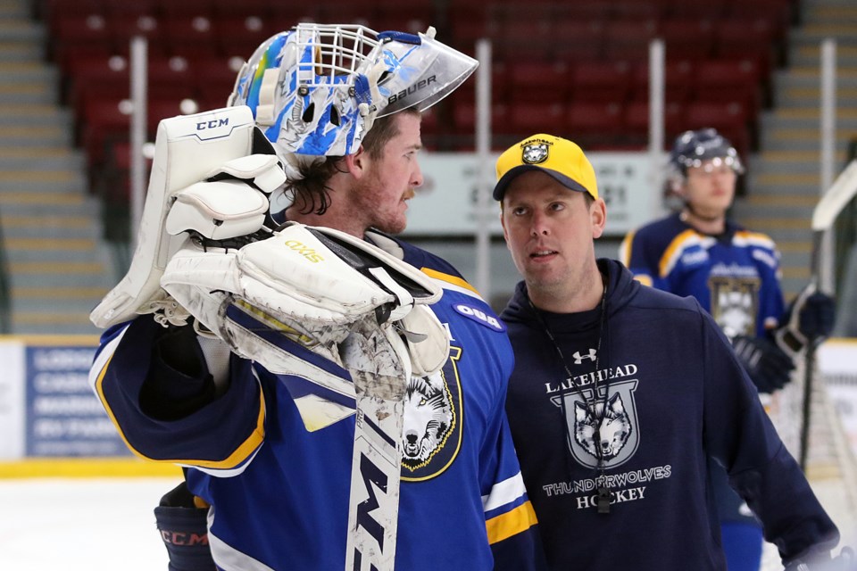Lakehead goaltender Blake Weyrick (left) speaks with coach Andrew Wilkins on Wednesday, Oct. 21, 2021 during practice at Fort William Gardens. (Leith Dunick, tbnewswatch.com)
